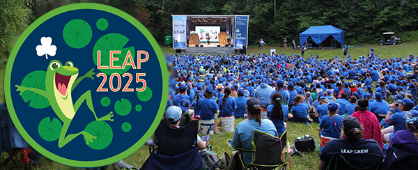 LEAP crest with the words LEAP Ontario & Nunavut Girl Guides Doe Lake 2025 overlayed on a picture of he backs of LEAP 2019 attendees all in blue sitting on a hill at Doe Lake camp watching the LEAP stage presentation.