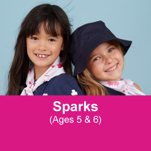 Two Girl Guides aged 5 to 6 smiling and linking arms