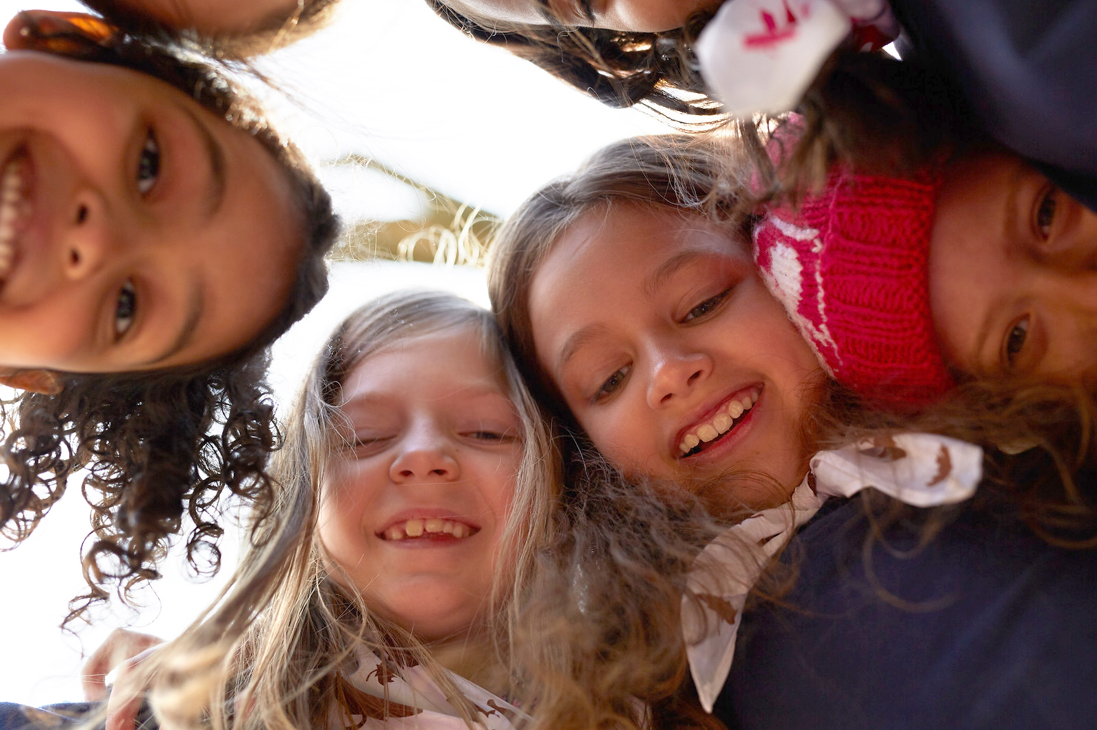 Group of Girl Guides girls aged 5 to 6 smiling in a huddle